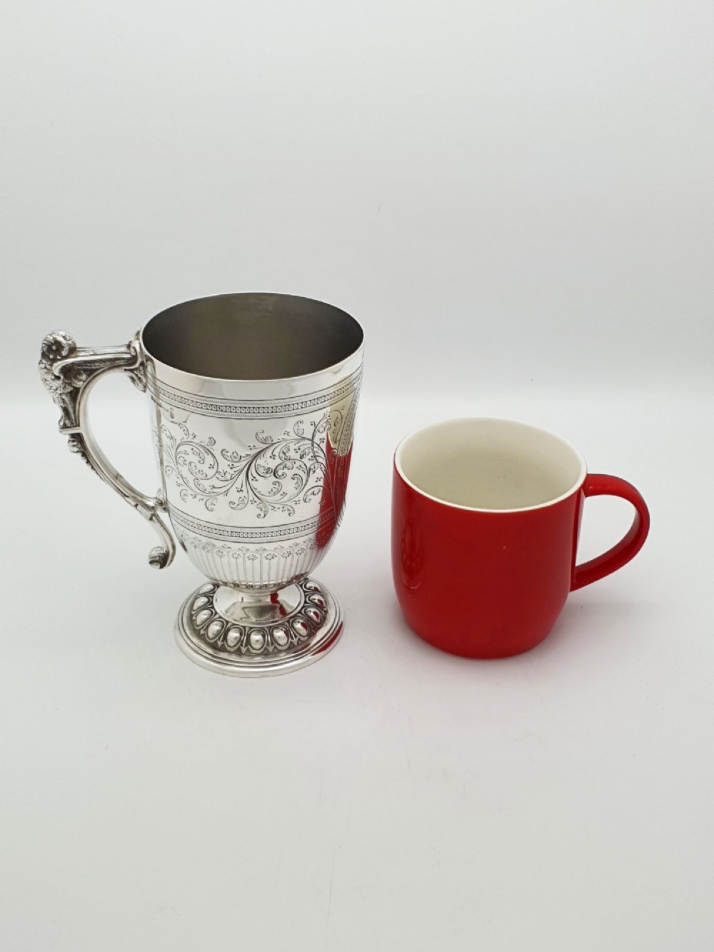 An Edwardian silver-plated tankard with intricate foliate engraving, a fluted pedestal base, and a decorative handle sculpted with an owl motif. View VIII