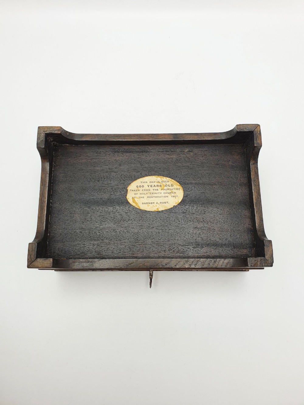 An Edwardian oak cigar box featuring decorative sterling silver corner mounts, a central shaped silver plaque, and a front keyhole with key. View XII