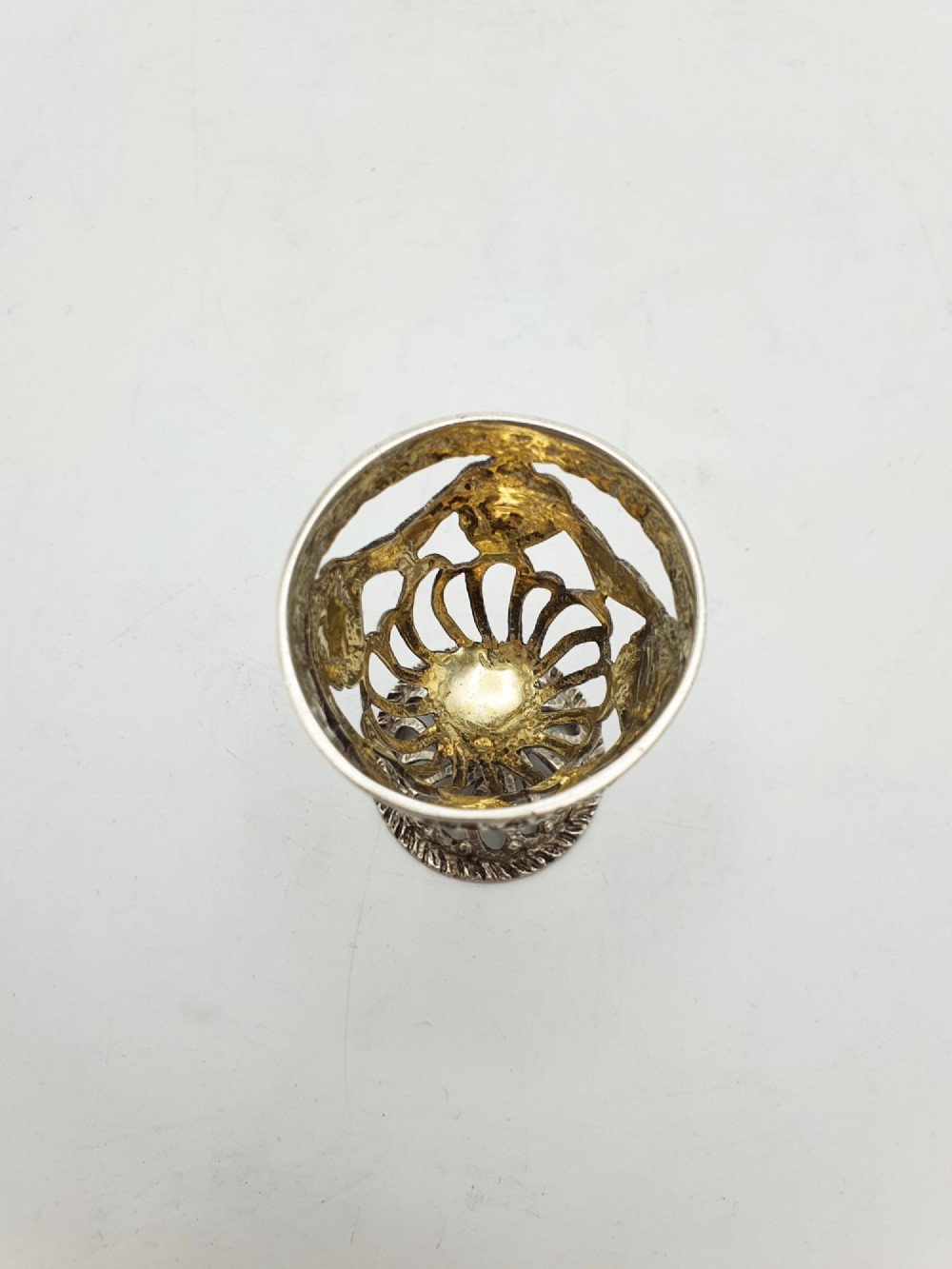 An Edwardian sterling silver egg cup featuring openwork lattice carving, a gilded interior wash, and a footed pedestal base. View III