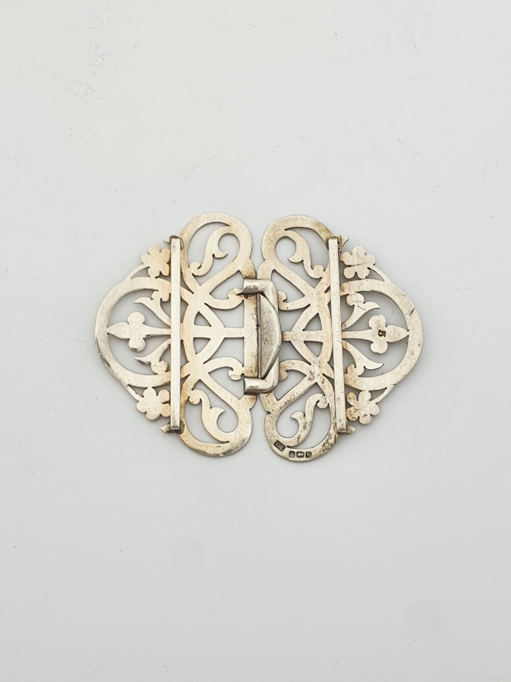 An Edwardian two-part sterling silver belt buckle featuring pierced scrollwork and floral motifs. View III