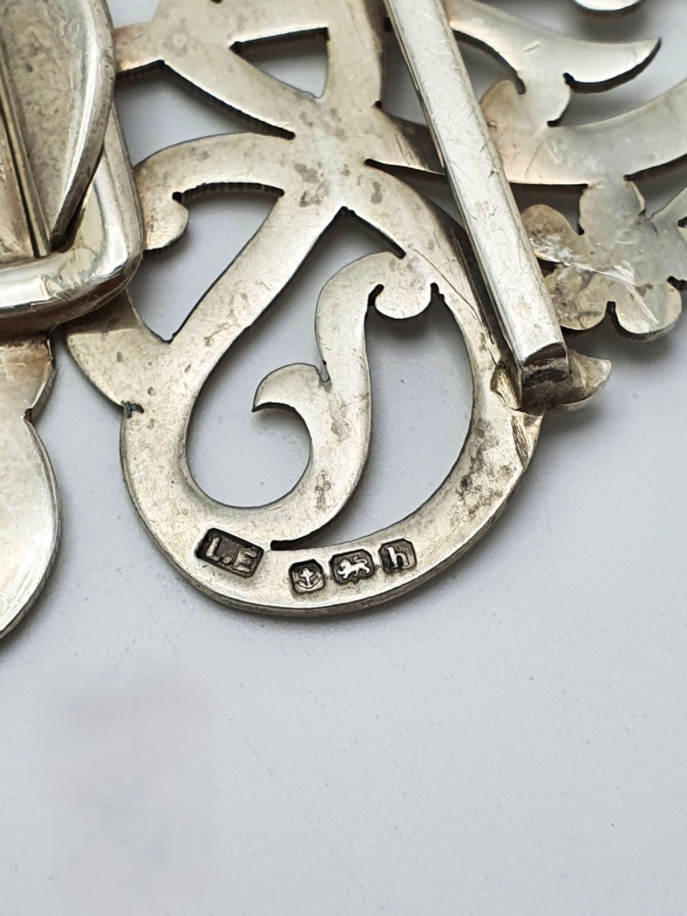 An Edwardian two-part sterling silver belt buckle featuring pierced scrollwork and floral motifs. View IV