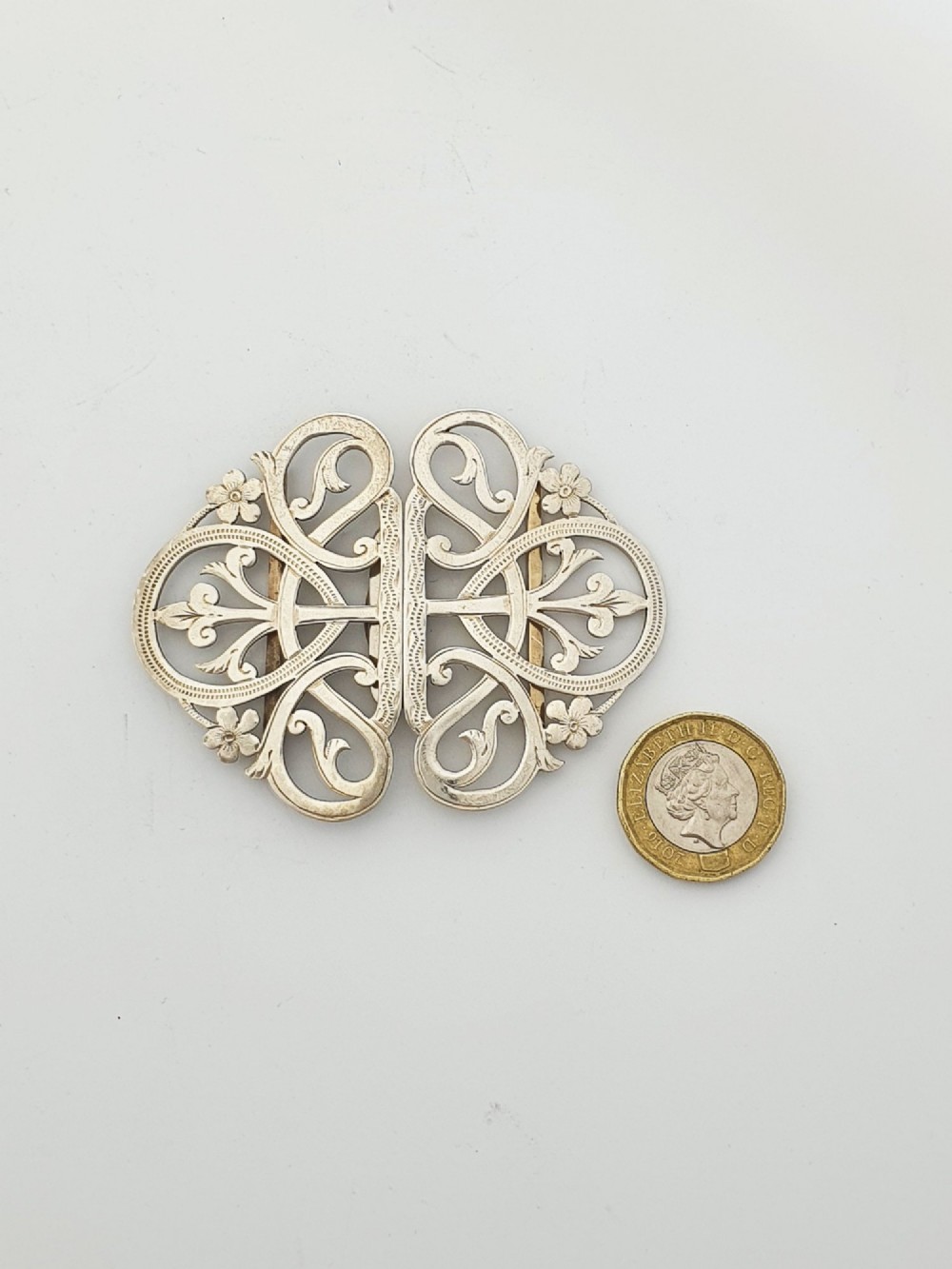 An Edwardian two-part sterling silver belt buckle featuring pierced scrollwork and floral motifs. View VI