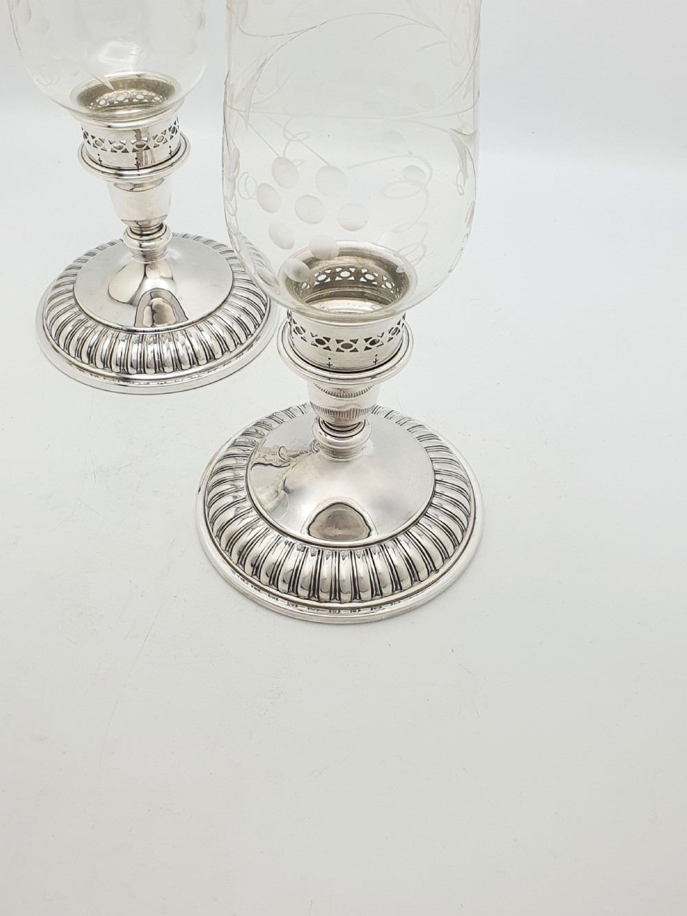 A pair of silver-plated candlestick bases fitted with clear etched glass hurricane shades featuring subtle floral patterns. View III