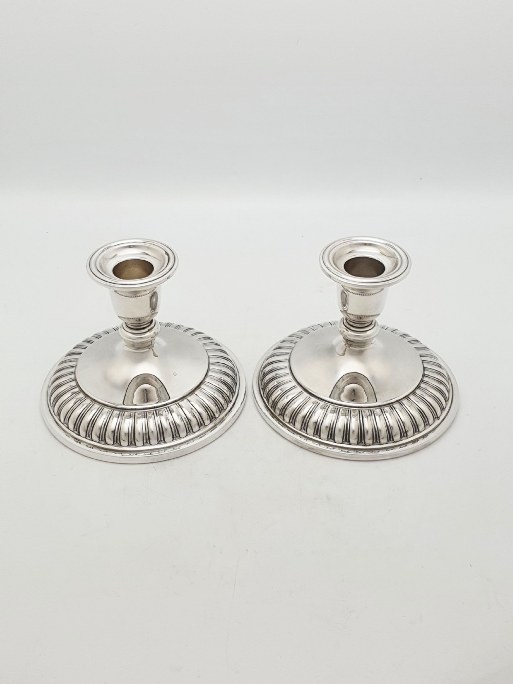 A pair of silver-plated candlestick bases fitted with clear etched glass hurricane shades featuring subtle floral patterns. View IX