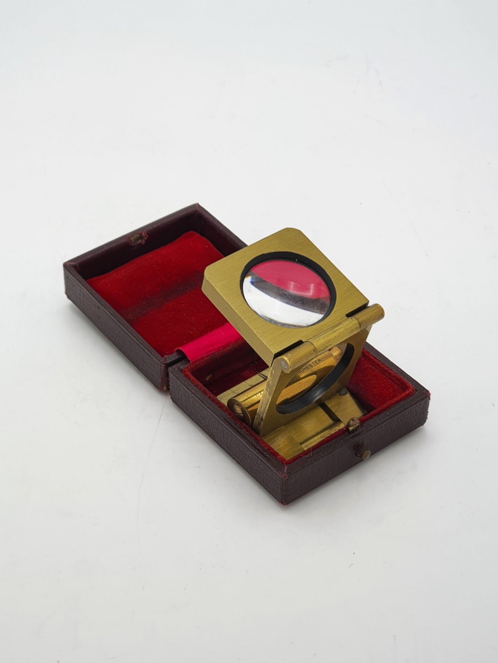 A vintage Edwardian folding brass linen tester loupe with a glass lens and measuring scale engraved on the base plate. View IV