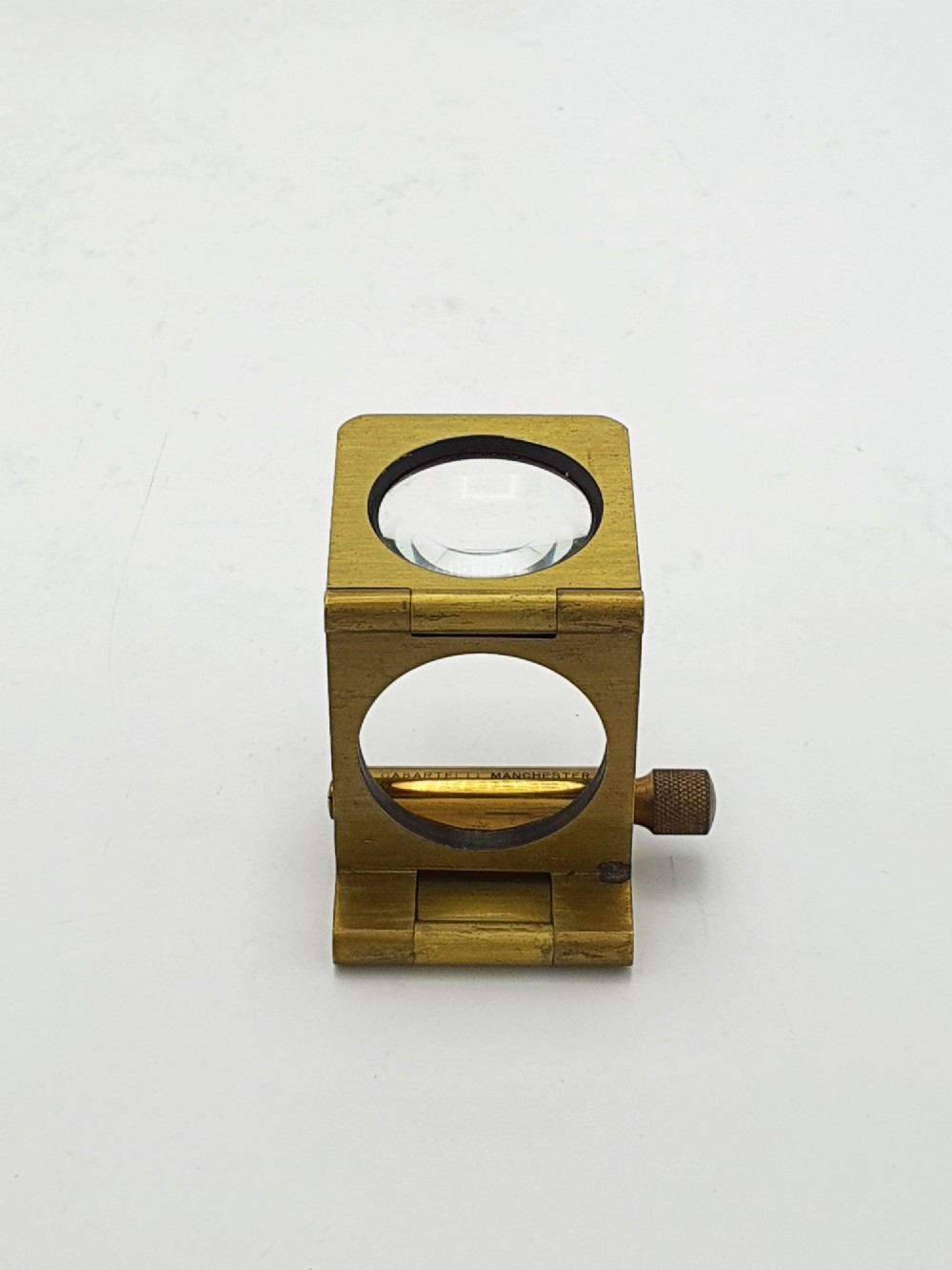 A vintage Edwardian folding brass linen tester loupe with a glass lens and measuring scale engraved on the base plate. View VI