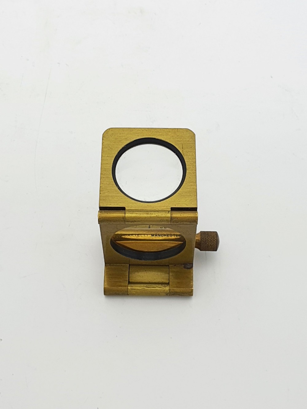 A vintage Edwardian folding brass linen tester loupe with a glass lens and measuring scale engraved on the base plate. View VII