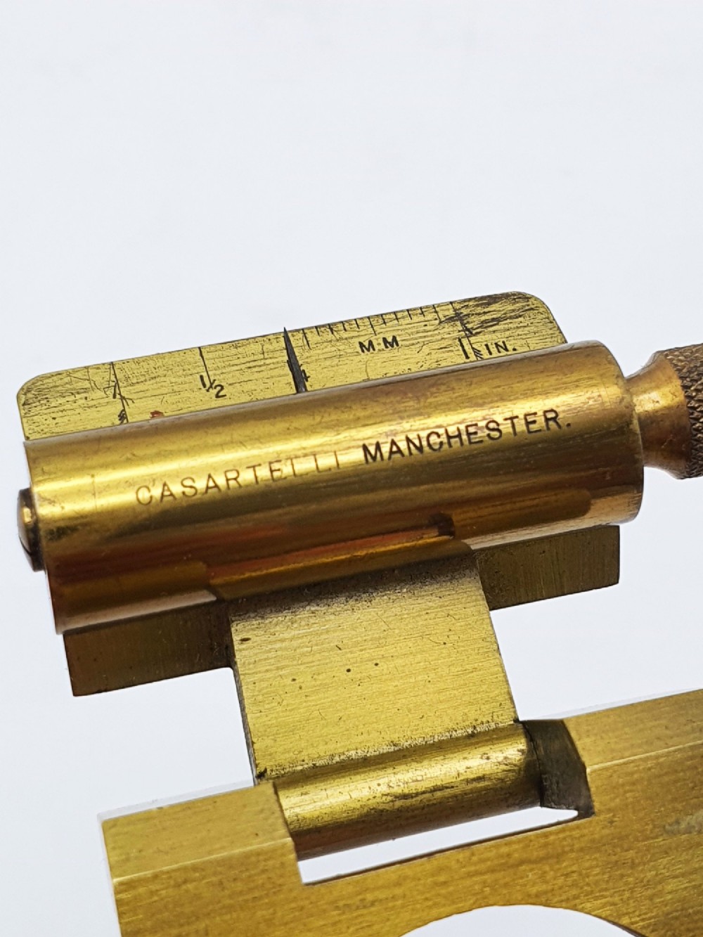 A vintage Edwardian folding brass linen tester loupe with a glass lens and measuring scale engraved on the base plate. View IX