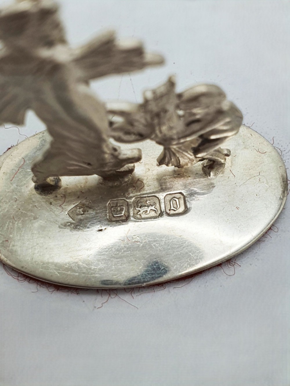 A set of four Edwardian sterling silver place card holders featuring figural motifs mounted on polished oval bases. View III