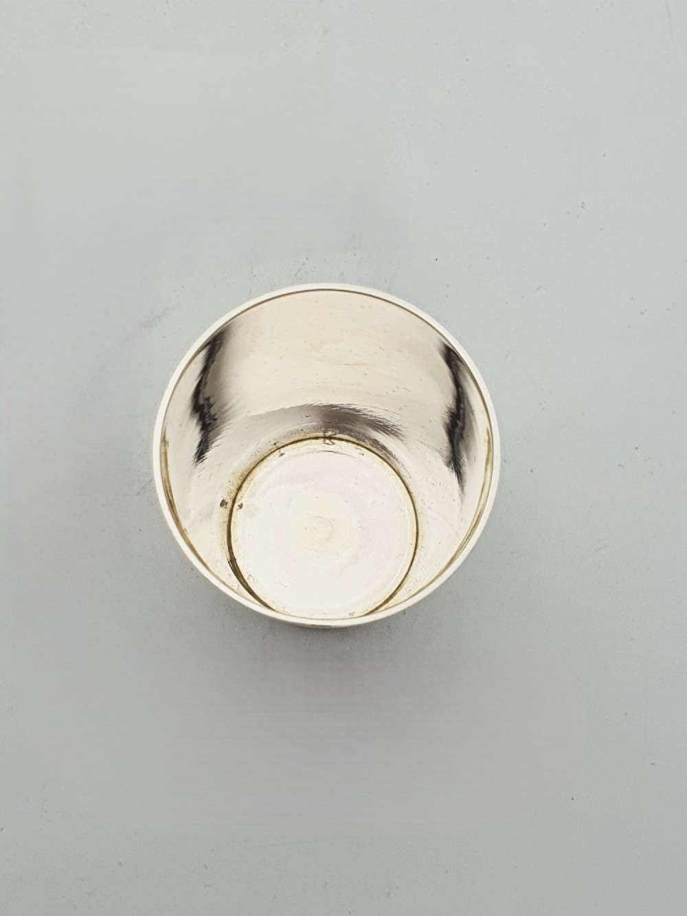 A polished Art Deco sterling silver travel beaker standing beside its fitted tan leather carrying case. View V