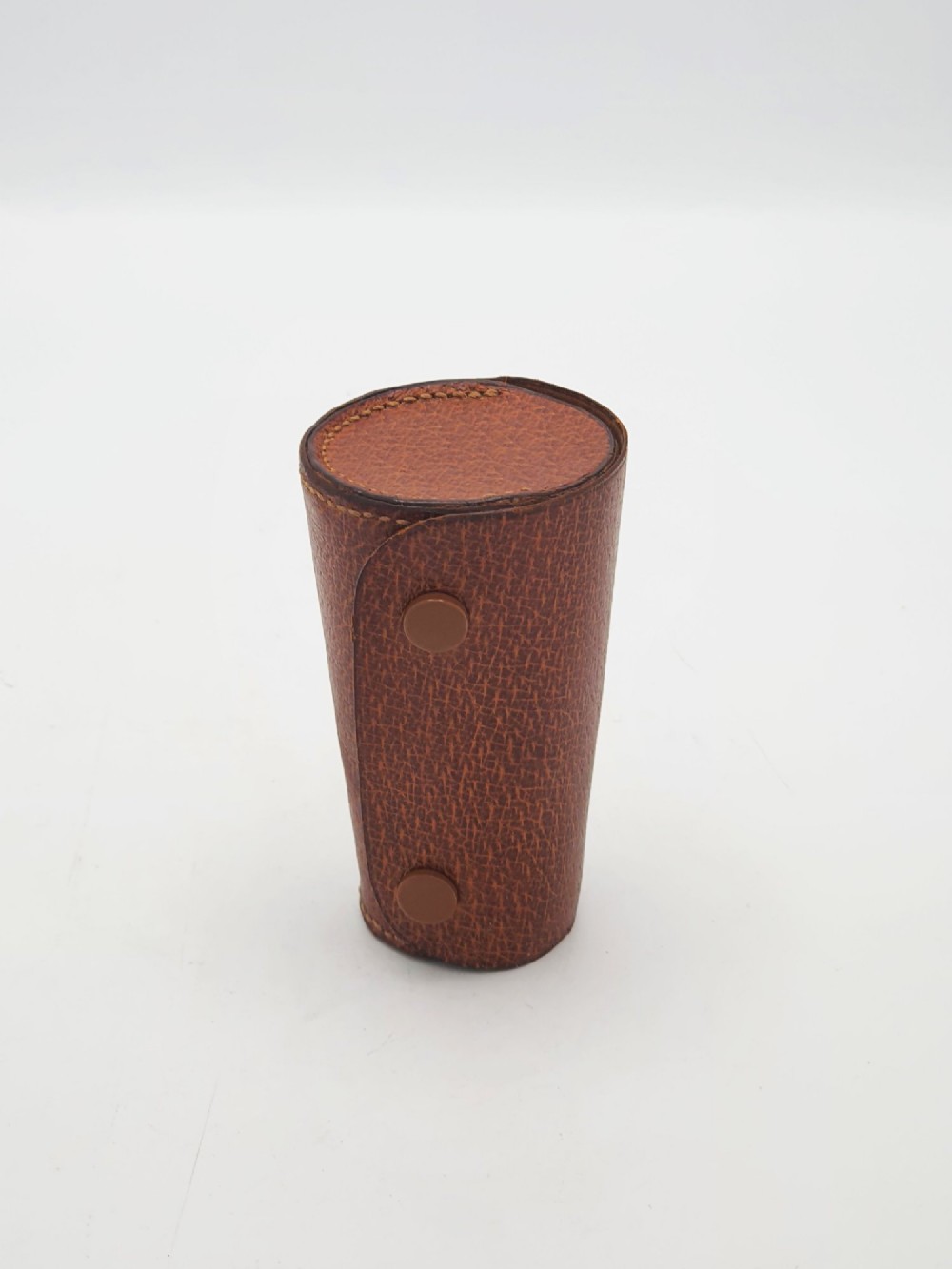A polished Art Deco sterling silver travel beaker standing beside its fitted tan leather carrying case. View VII