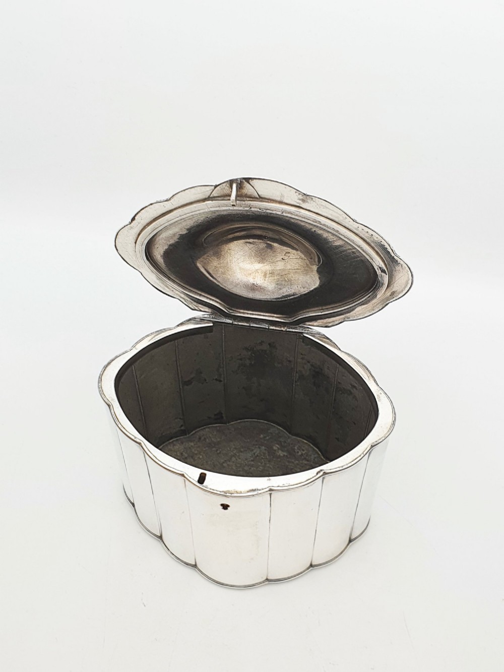 A lobed Georgian Sheffield plated tea caddy featuring vertical fluting, a central keyhole, and a domed lid topped with an urn finial. View III