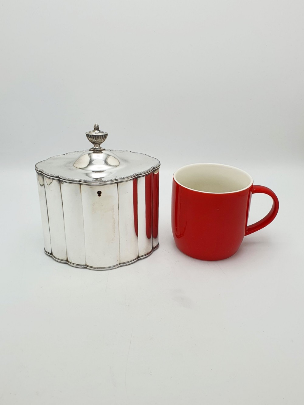 A lobed Georgian Sheffield plated tea caddy featuring vertical fluting, a central keyhole, and a domed lid topped with an urn finial. View VIII
