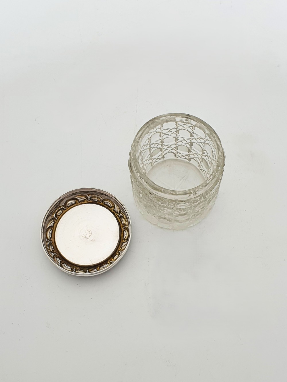 An Edwardian round cut-glass vanity jar featuring a sterling silver mounted lid inset with a hand-painted porcelain plaque depicting an eighteenth-century courting couple. View III