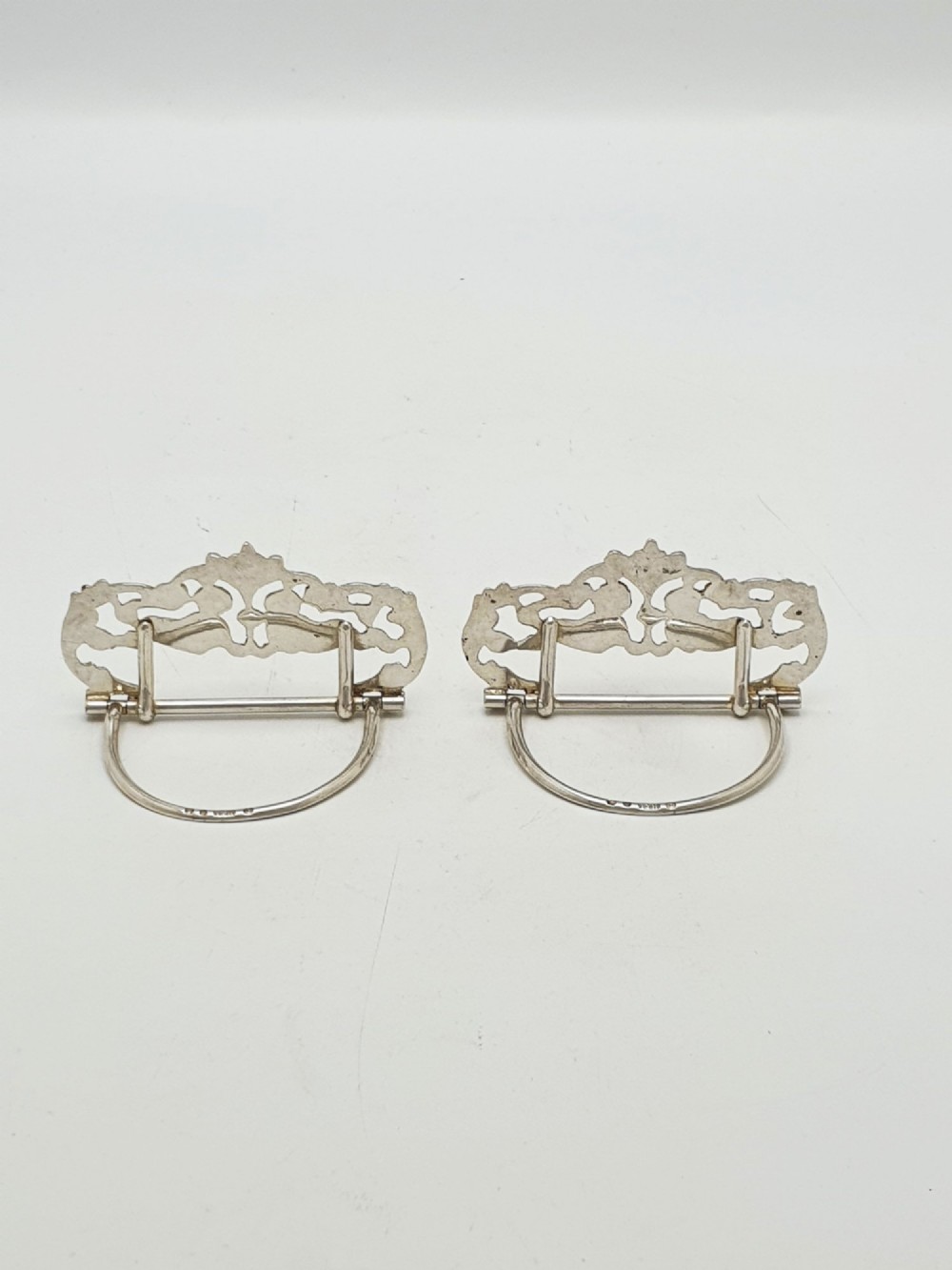 A pair of Victorian sterling silver place card holders featuring detailed cherubs framed by pierced scrolling foliage. View III