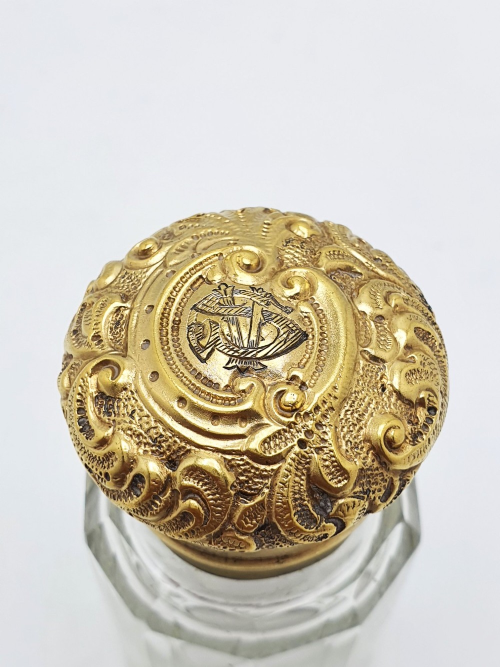 A clear faceted cut glass scent bottle featuring an embossed gilt sterling silver cap. View VIII