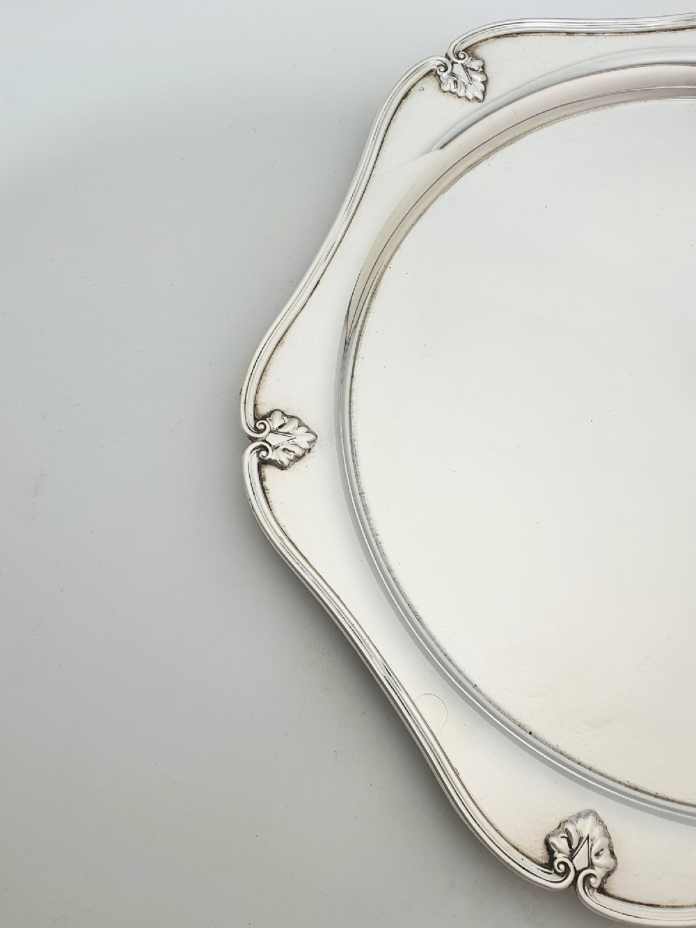 An Art Deco silver-plated circular cocktail tray featuring a scalloped rim decorated with stylised leaf motifs. View II