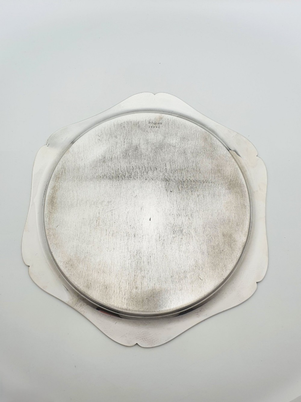 An Art Deco silver-plated circular cocktail tray featuring a scalloped rim decorated with stylised leaf motifs. View III