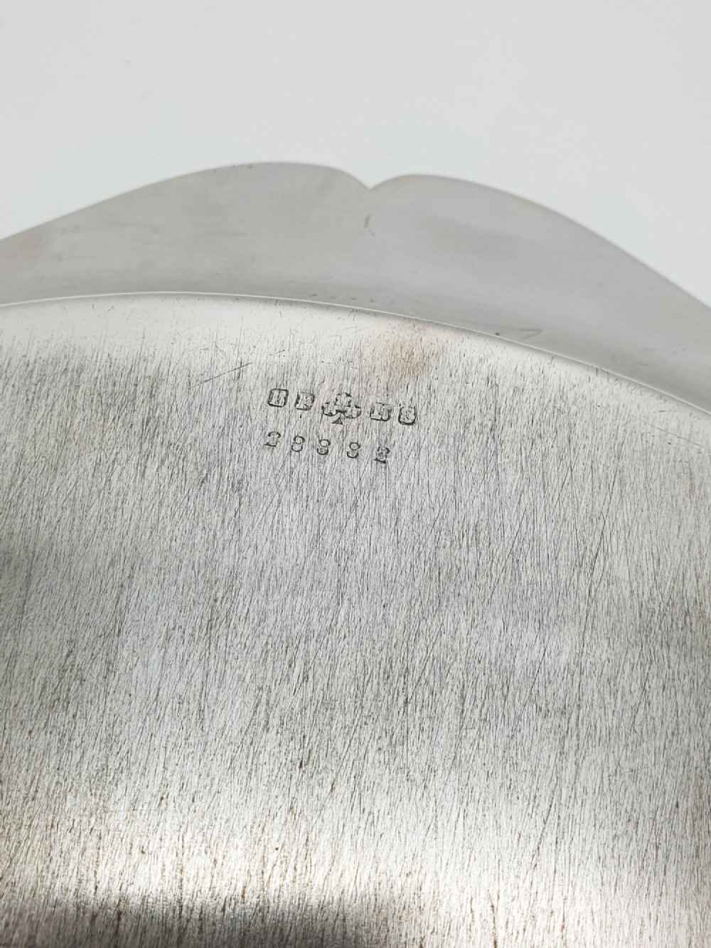 An Art Deco silver-plated circular cocktail tray featuring a scalloped rim decorated with stylised leaf motifs. View IV
