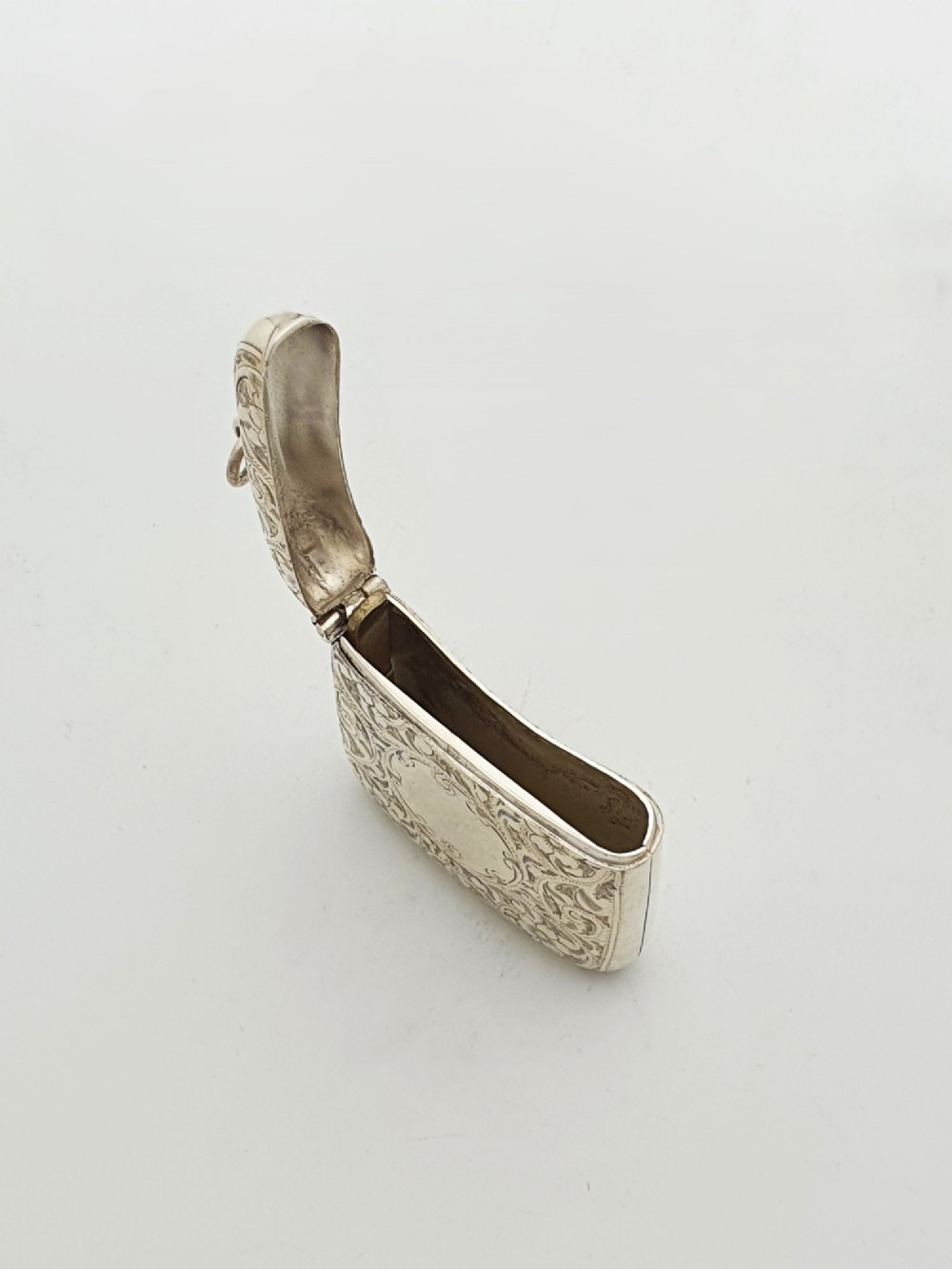 An open Edwardian sterling silver vesta case displaying an engraved hinged lid and two interior oval photo frame apertures. View IV