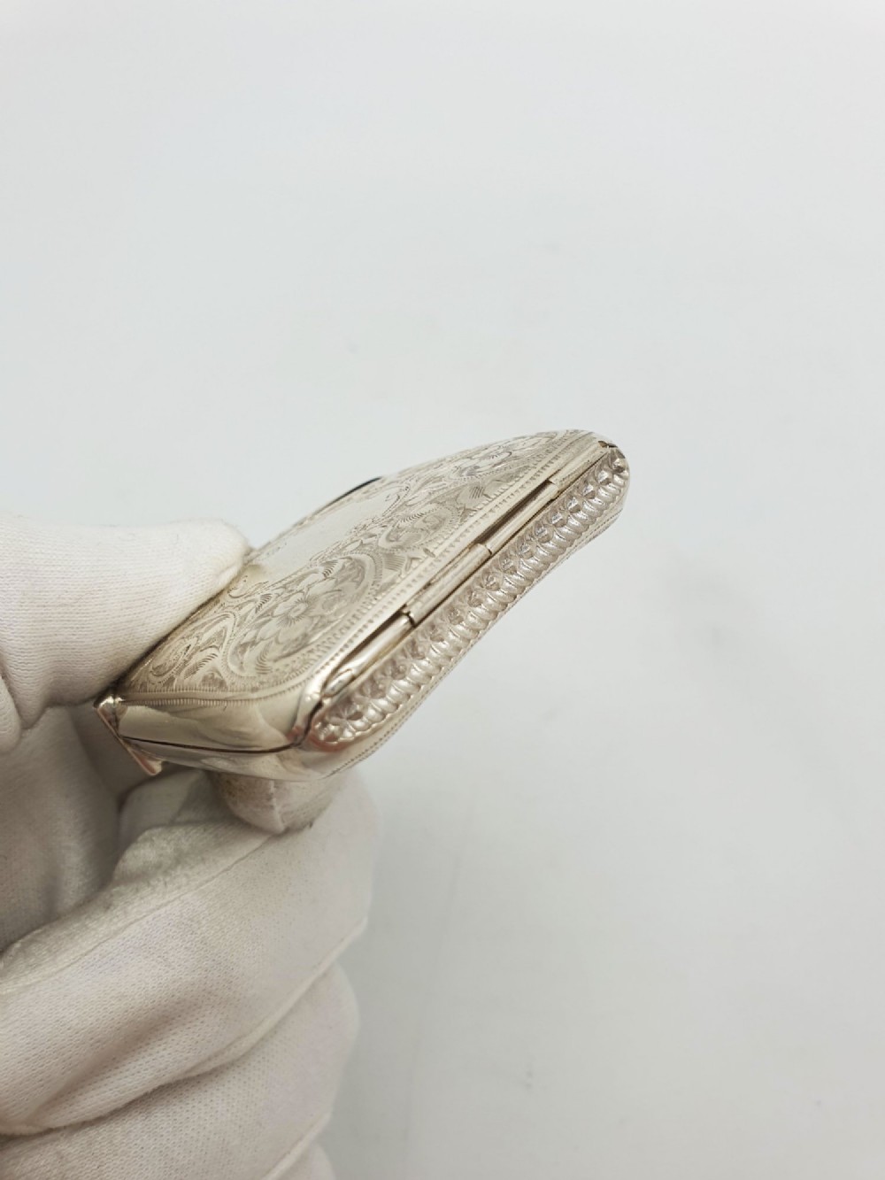 An open Edwardian sterling silver vesta case displaying an engraved hinged lid and two interior oval photo frame apertures. View VII