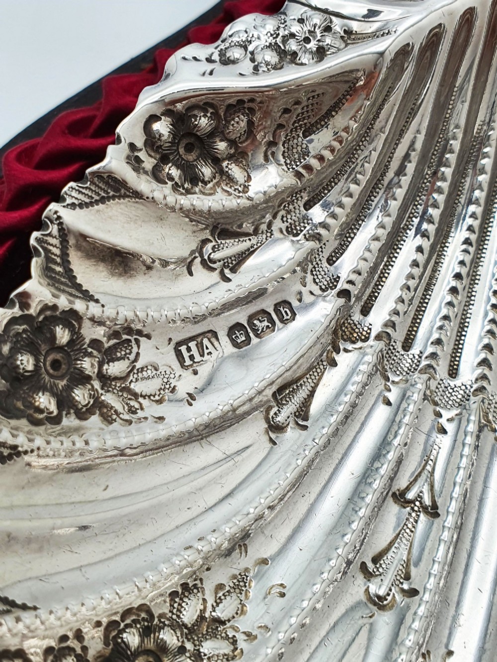 A Victorian sterling silver scallop shell butter dish and matching engraved spreader knife resting inside a fitted red and black velvet presentation case. View IV