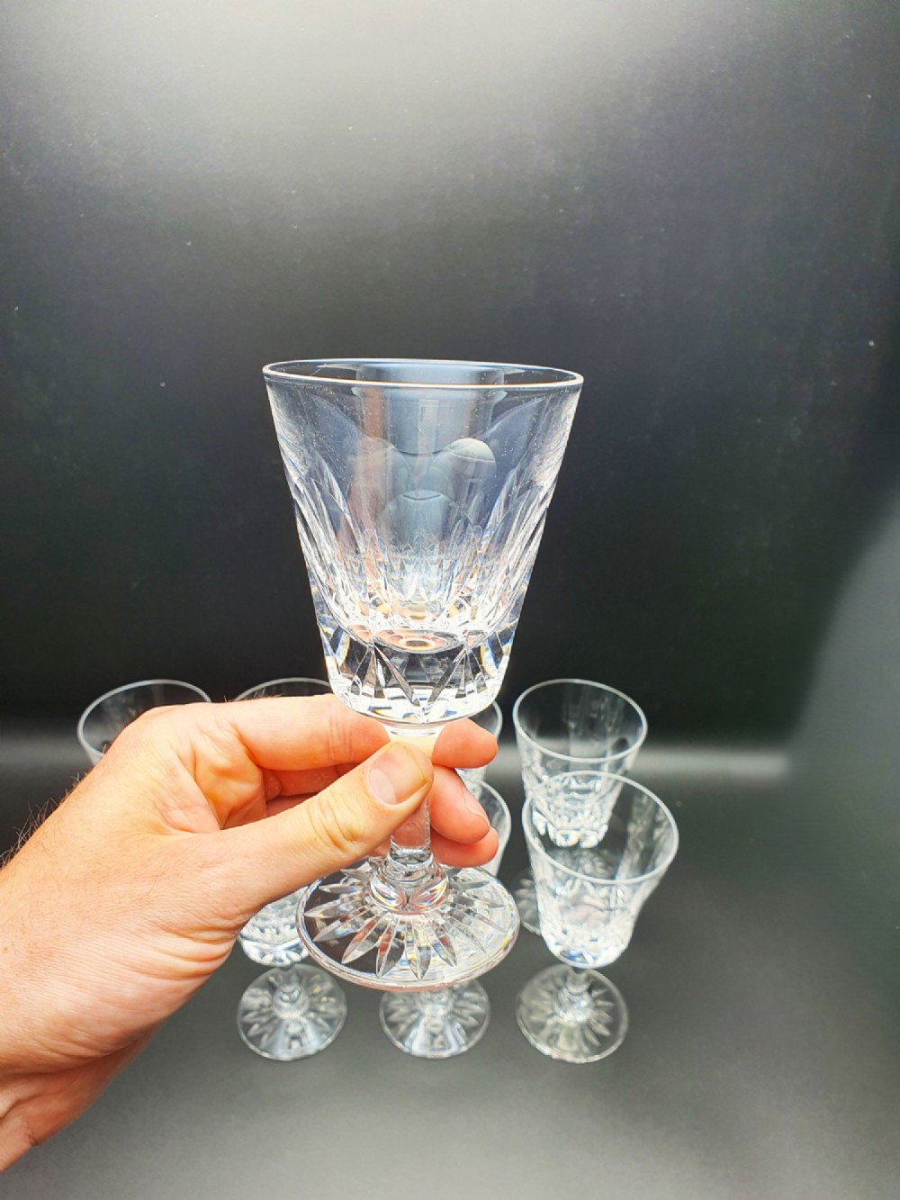 A set of eight clear cut glass wine glasses featuring faceted bowls and starburst pattern bases. View III