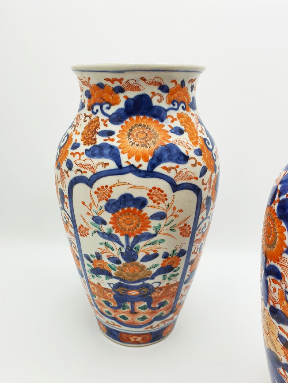 A pair of antique Japanese Imari porcelain vases decorated with cobalt blue and iron-red floral motifs within framed panels. View III