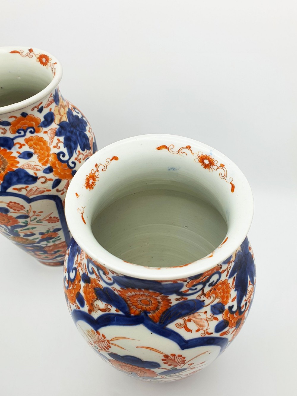 A pair of antique Japanese Imari porcelain vases decorated with cobalt blue and iron-red floral motifs within framed panels. View IV