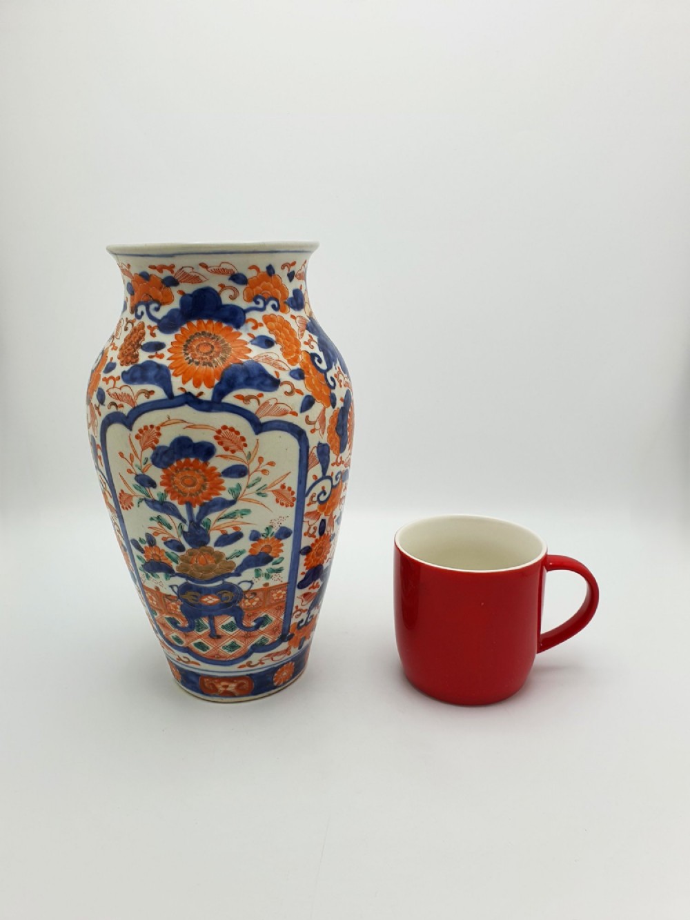 A pair of antique Japanese Imari porcelain vases decorated with cobalt blue and iron-red floral motifs within framed panels. View X