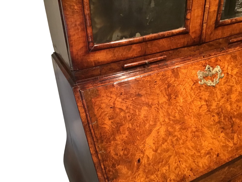 A two-part Georgian walnut bureau bookcase featuring a moulded top cabinet with two glazed doors above a fall-front desk with a green leather writing surface and a shaped lower drawer base. View III