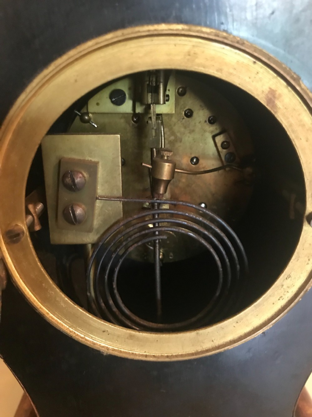 A Rococo-style French mantel clock featuring a faux tortoiseshell case with ornate scrolled bronze mounts and a white enamel dial with Roman numerals. View II
