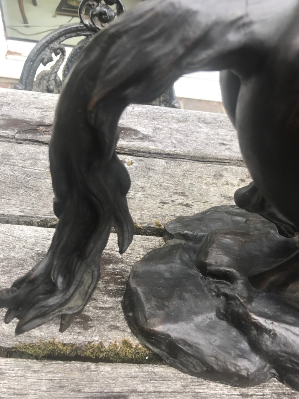 A dark patinated bronze sculpture depicting a muscular male groom attempting to restrain a rearing horse on a naturalistic base. View V