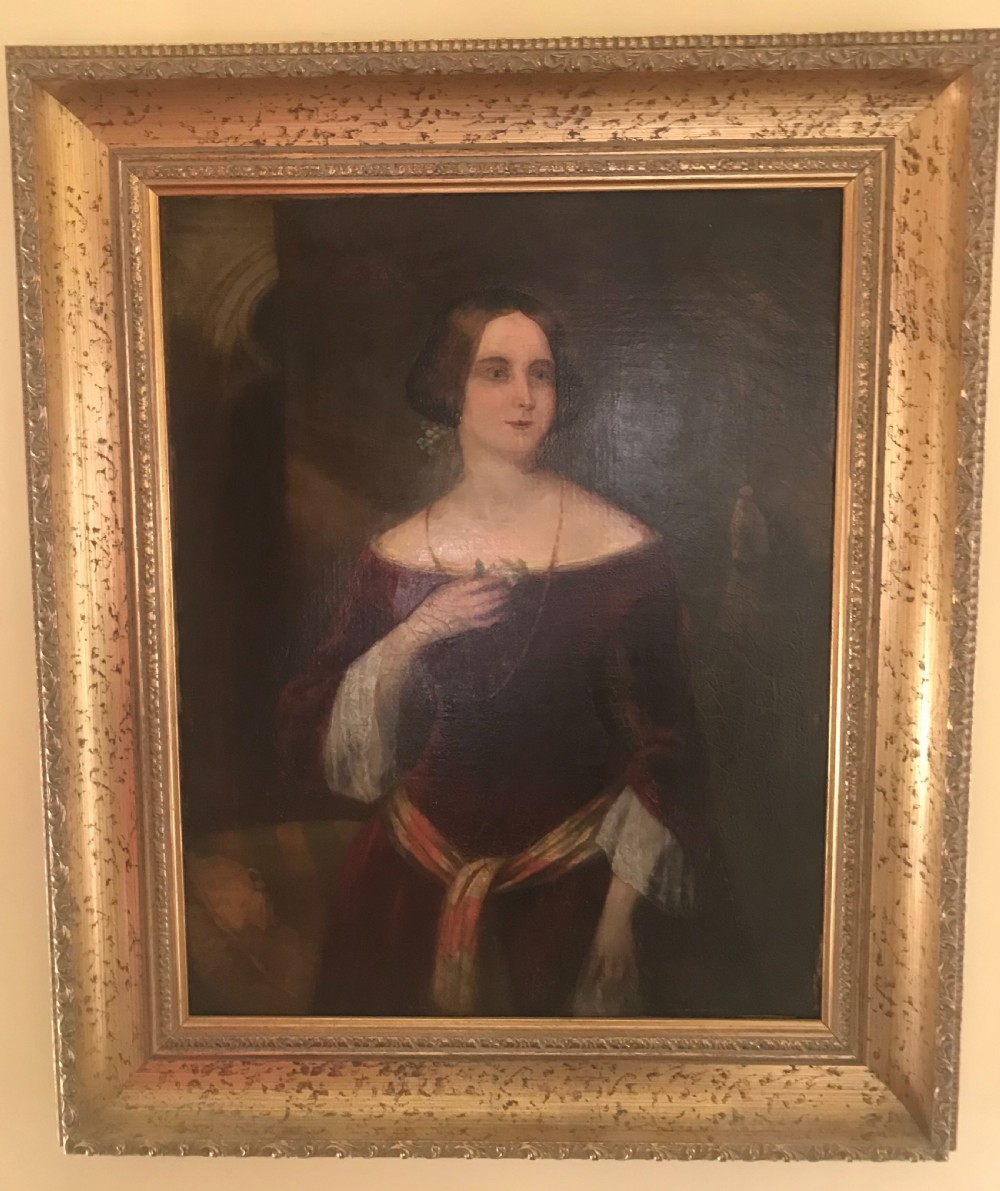 An antique oil painting on canvas depicting a woman in a deep red off-the-shoulder gown, enclosed within a wide gilded wooden frame.