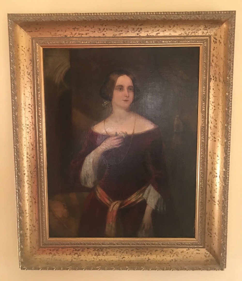 An antique oil painting on canvas depicting a woman in a deep red off-the-shoulder gown, enclosed within a wide gilded wooden frame. View IV