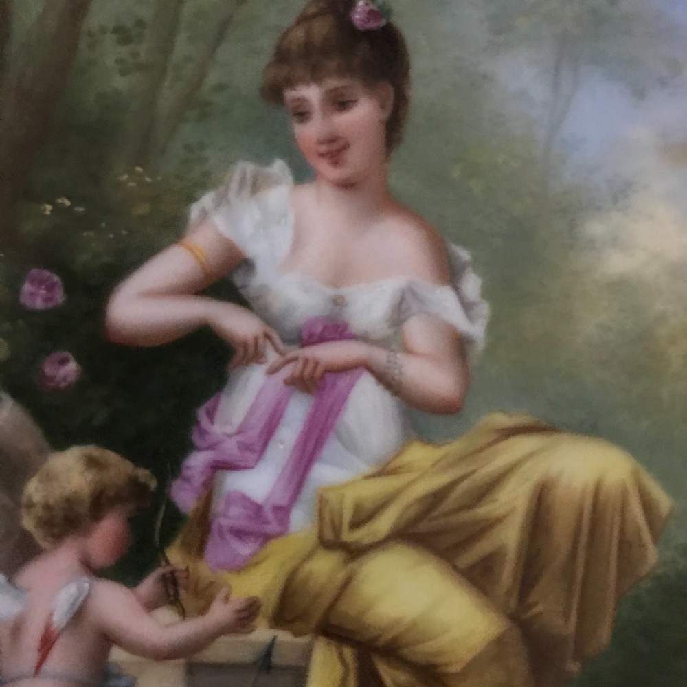An octagonal antique porcelain cabinet plate with a cobalt blue and gold gilded border surrounding a central hand-painted scene of a classical woman and cherub. View II