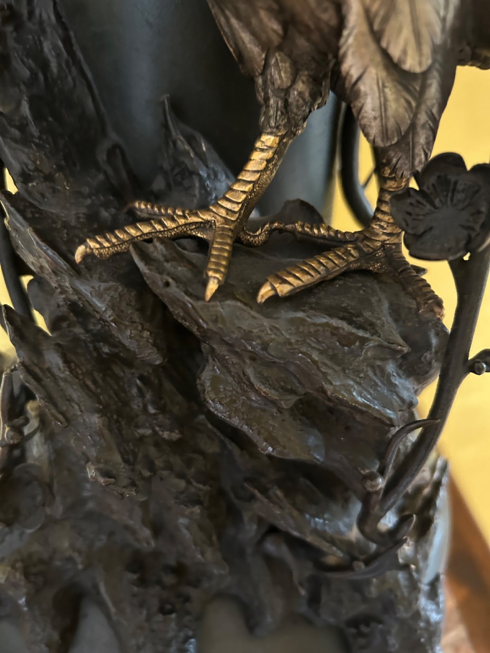 A dark patinated Japanese Meiji period bronze vase featuring a flared scalloped rim and a sculptural hawk perched on high-relief rockwork. View II