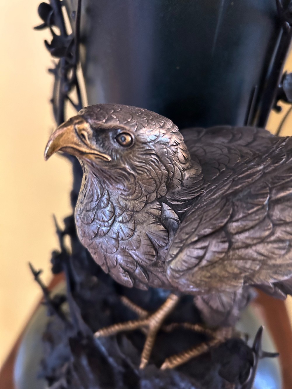 A dark patinated Japanese Meiji period bronze vase featuring a flared scalloped rim and a sculptural hawk perched on high-relief rockwork. View III
