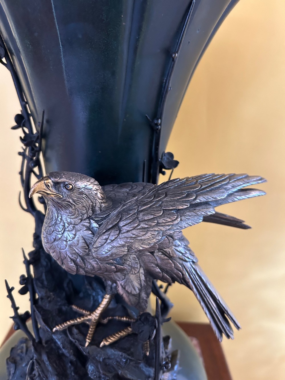 A dark patinated Japanese Meiji period bronze vase featuring a flared scalloped rim and a sculptural hawk perched on high-relief rockwork. View IV