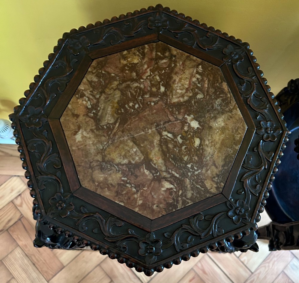 A pair of octagonal Chinese dark padouk wood plant stands with inset marble tops, pierced openwork aprons, lower shelves, and claw feet. View II