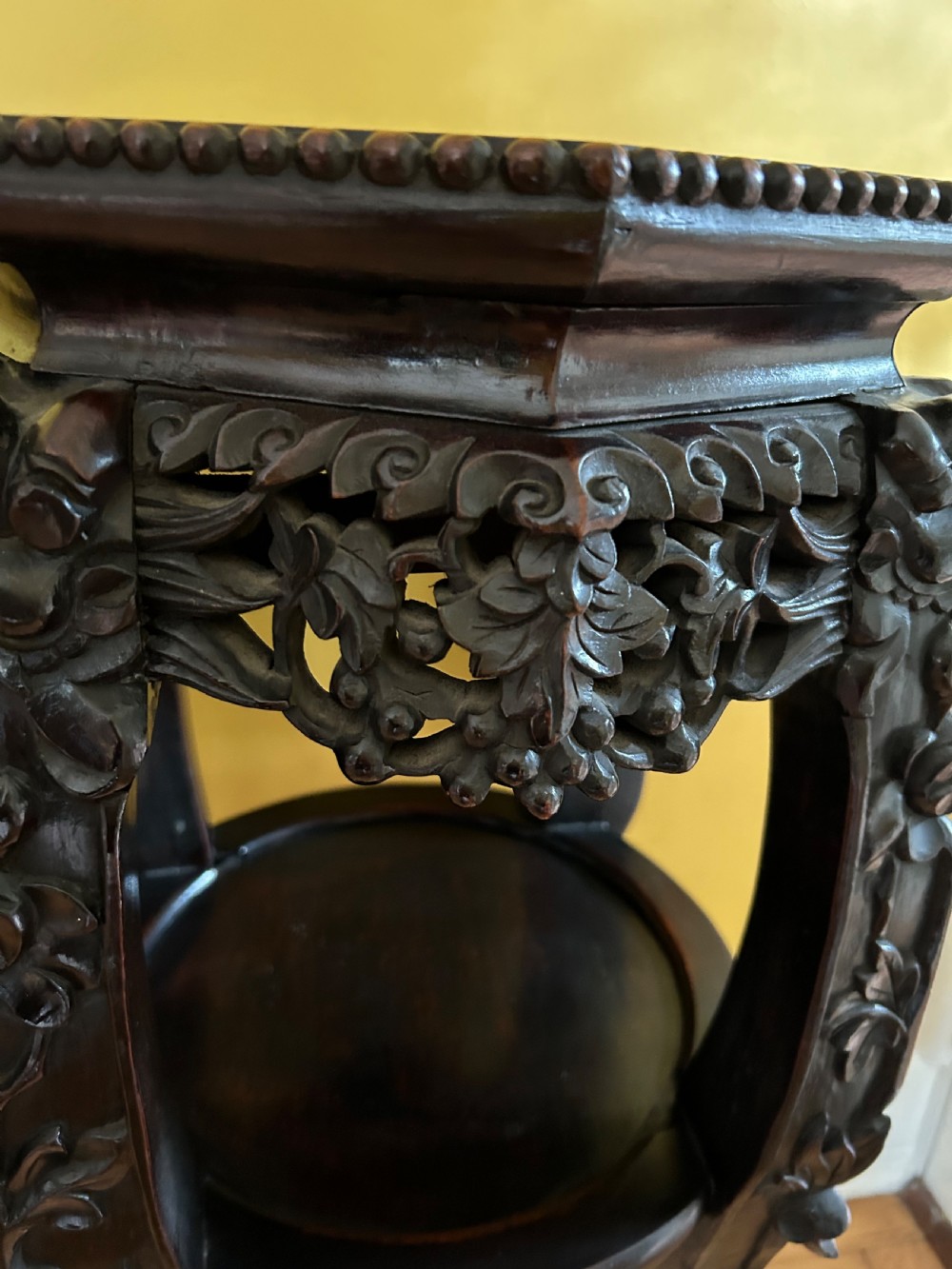 A pair of octagonal Chinese dark padouk wood plant stands with inset marble tops, pierced openwork aprons, lower shelves, and claw feet. View V