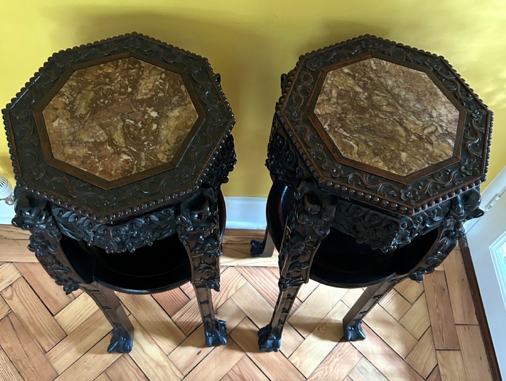 A pair of octagonal Chinese dark padouk wood plant stands with inset marble tops, pierced openwork aprons, lower shelves, and claw feet. View VII