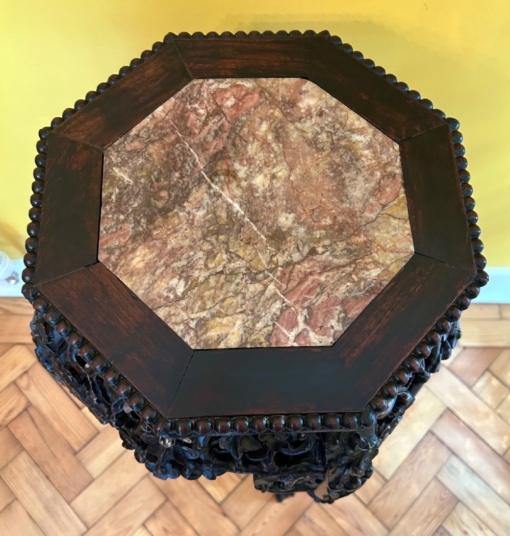 An intricately carved dark hardwood Chinese plant stand featuring an octagonal beaded top, openwork floral apron, cabriole legs, and a carved lower cross-stretcher. View III