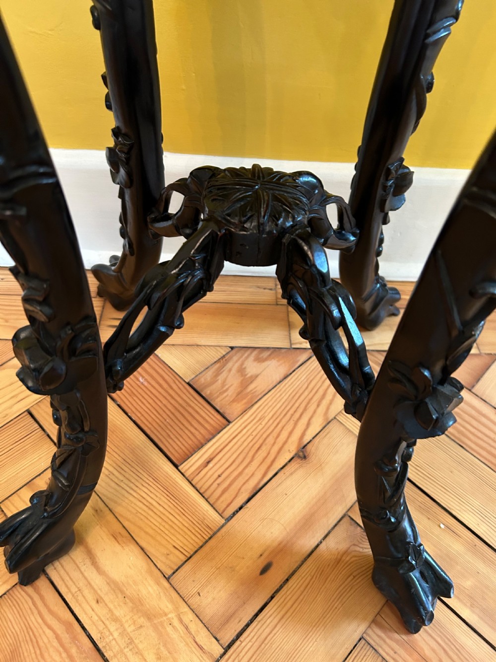 An intricately carved dark hardwood Chinese plant stand featuring an octagonal beaded top, openwork floral apron, cabriole legs, and a carved lower cross-stretcher. View VI