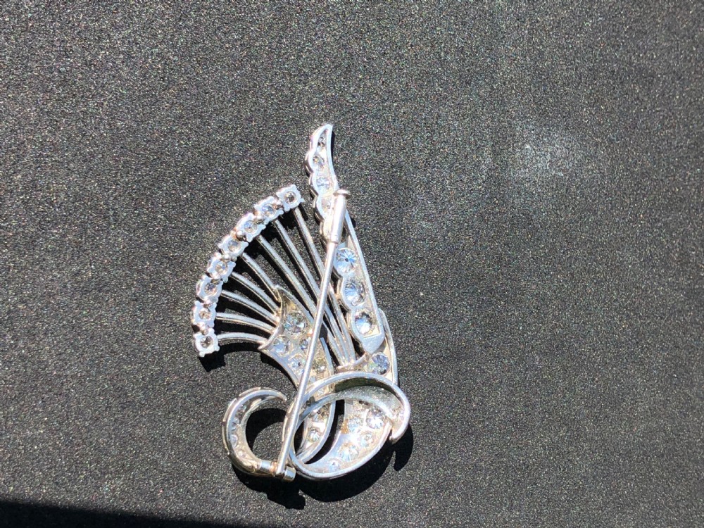 A late Art Deco platinum brooch styled as sweeping floral sprays and swirls encrusted with round brilliant cut diamonds. View II