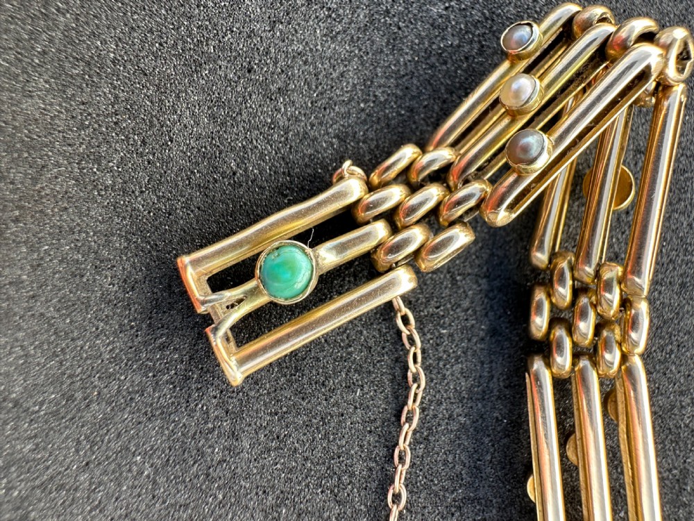 An antique 15ct yellow gold link bracelet featuring set turquoise cabochons and small seed pearls along structured openwork links. View II