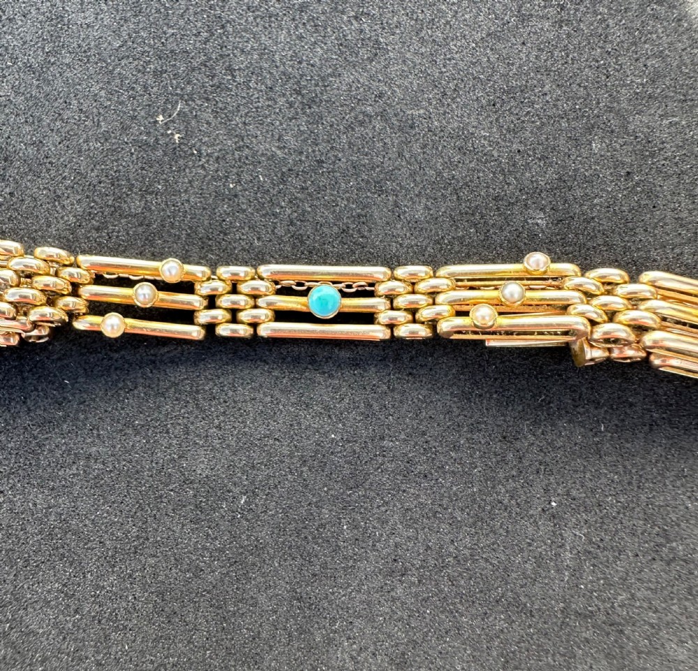 An antique 15ct yellow gold link bracelet featuring set turquoise cabochons and small seed pearls along structured openwork links. View VI