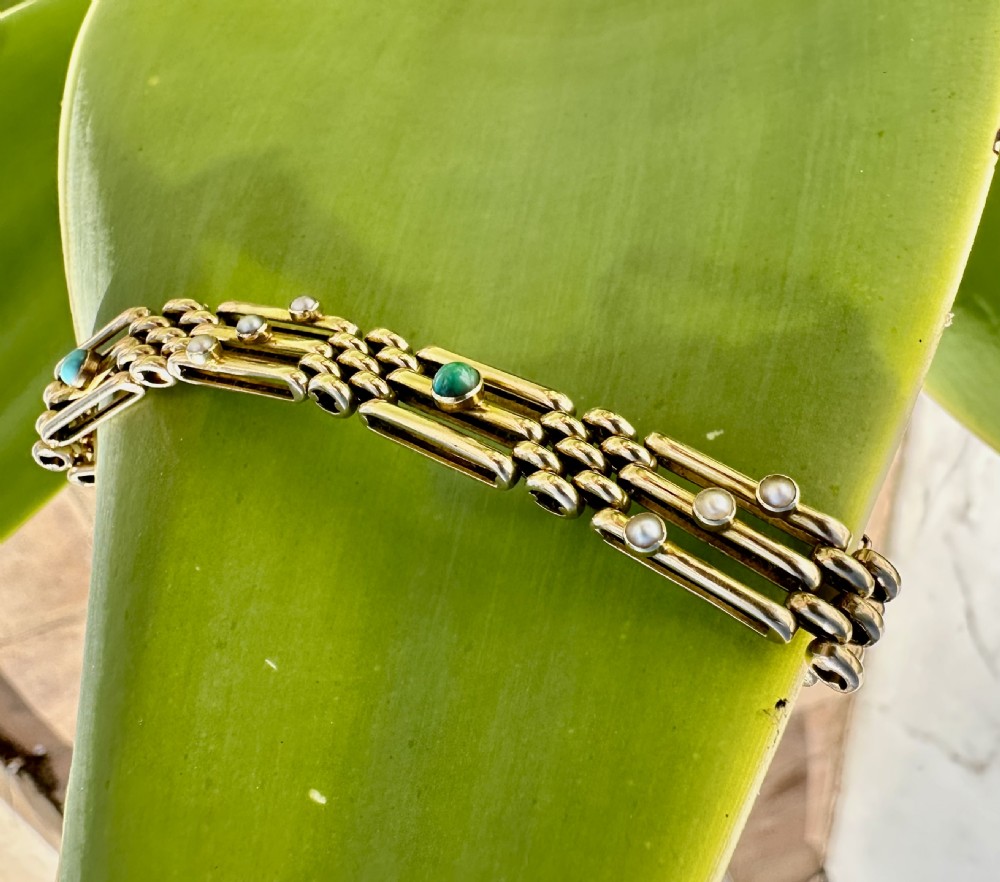 An antique 15ct yellow gold link bracelet featuring set turquoise cabochons and small seed pearls along structured openwork links. View VII
