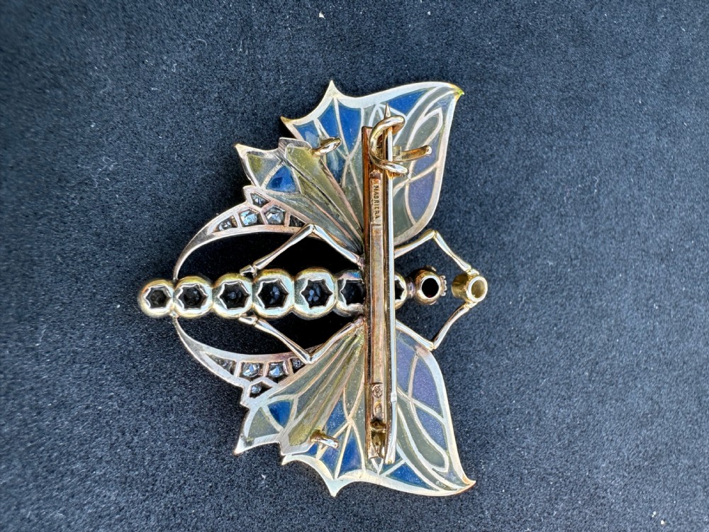 An Art Nouveau style butterfly brooch featuring blue and yellow plique-a-jour enamel wings with a diamond-paved body and gold framework. View VI