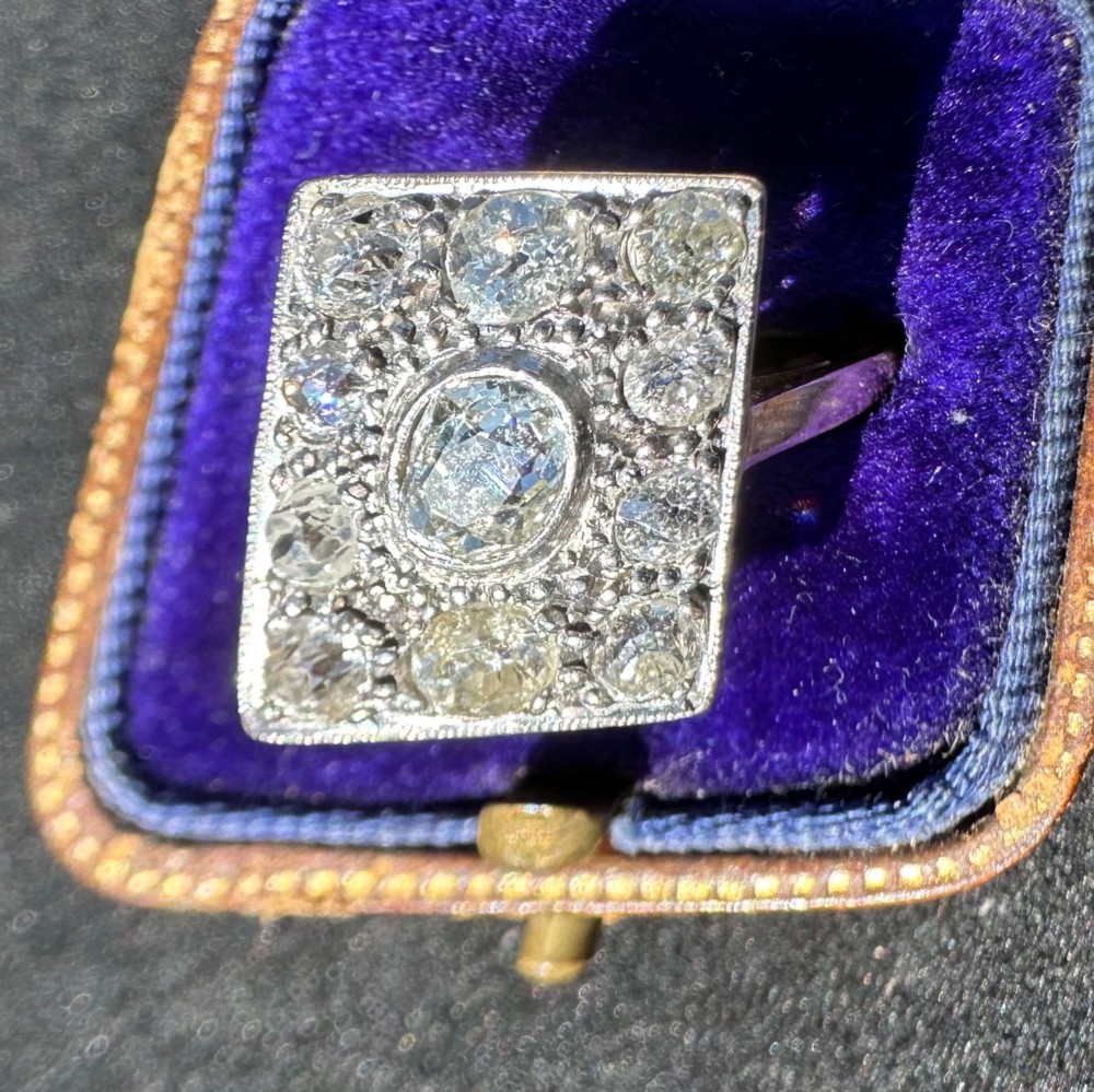 A rectangular platinum and diamond panel ring set with multiple diamonds on an 18ct gold shank.